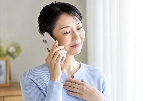 柏市葬儀 はばたきグループへ電話で葬儀の事前相談をする女性