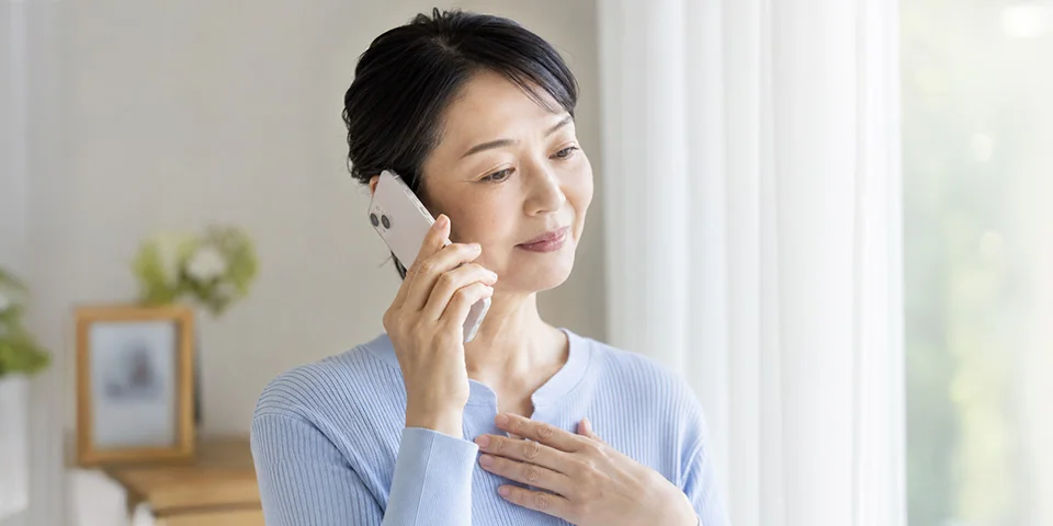 柏市葬儀 はばたきグループへ電話で葬儀の事前相談をする女性
