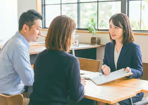 葬儀社スタッフと40代前後の夫婦が、大和市で行う葬儀について打ち合わせをしている様子