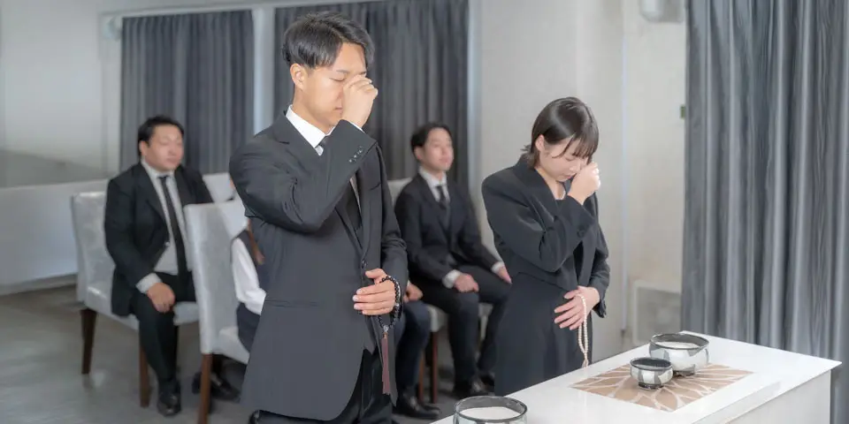 お通夜で、参列者(男性1名・女性1名)が焼香をあげている様子