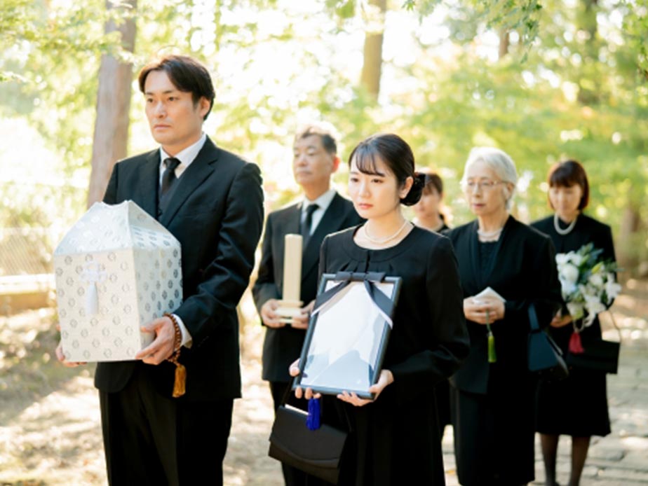 遺族が骨壷を抱えている様子
